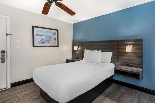 a bedroom with a large bed and a ceiling fan at SureStay Hotel by Best Western Virginia Beach Royal Clipper in Virginia Beach