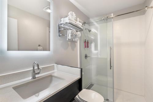 a white bathroom with a sink and a shower at SureStay Hotel by Best Western Virginia Beach Royal Clipper in Virginia Beach
