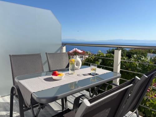a blue table with a bowl of fruit on a balcony at Alexandros Luxury Apartment in Glossa