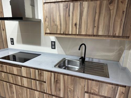 a kitchen with a sink and wooden cabinets at Pilgrims House II in Lourenzá