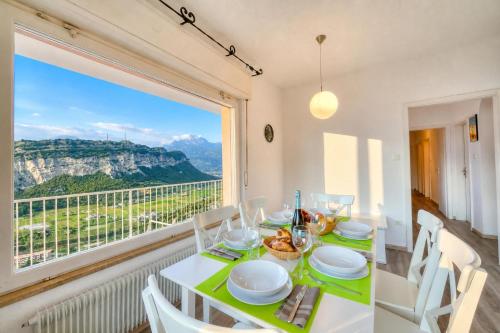 a dining room with a table and a large window at Villa Panorama with Private Pool in Nago-Torbole