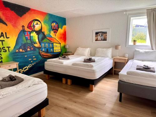 a room with three beds and a painting on the wall at The Stykkishólmur Inn by Ourhotels in Stykkishólmur
