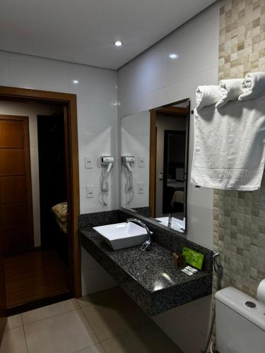 a bathroom with a sink and a mirror at Hotel Maestro Premium Cascavel in Cascavel