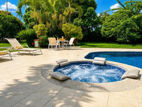 a small pool with chairs and a table and a patio at Villa de lujo a 20 mins Buga con Piscina privada, Jacuzzi y BBQ in Guacarí