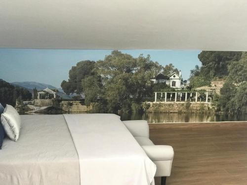 a bedroom with a white bed and a view of a house at Ardales Loft in Ardales
