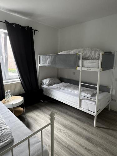 a bedroom with two bunk beds and a table at Gästehaus OG in Cologne