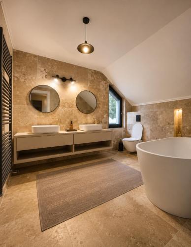a bathroom with two sinks and a tub and mirrors at Garden Retreat Keyhouse in Bran
