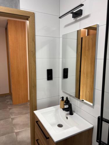 a bathroom with a sink and a mirror at SWP Plac Solny 4 z klimatyzacją in Głogów