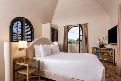 a bedroom with a large white bed and a window at Montecito Inn in Santa Barbara
