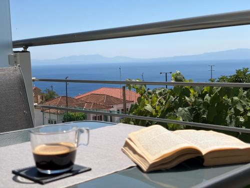 a cup of coffee and an open book sitting on a table at Alexandros Luxury Apartment in Glossa
