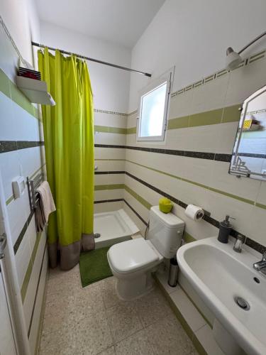 a bathroom with a white toilet and a sink at Dar Elferdaous in Al Medou