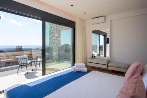 a bedroom with a bed and a large window at Blue Sunrise Villa 2 in Afantou