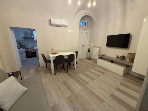 a living room with a table and chairs and a television at Ad un Passo dal Duomo in Bovino