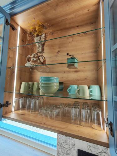 a shelf with glasses and dishes on it at Casa Bellea in Belej