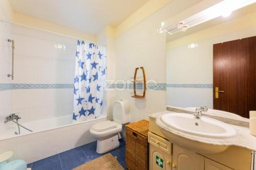 a bathroom with a sink and a toilet and a tub at Casa da Lagoa II in Terras de Bouro