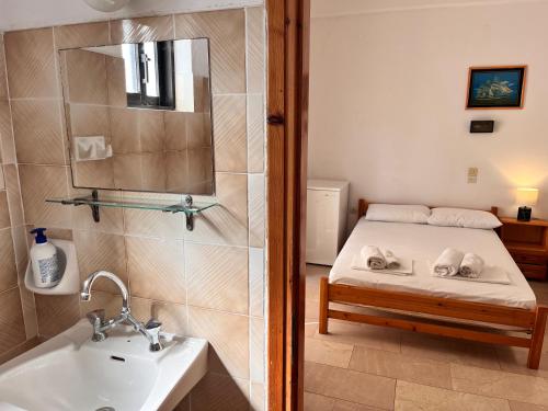 a bathroom with a bed and a sink and a mirror at Villa Xenia in Ammoudia
