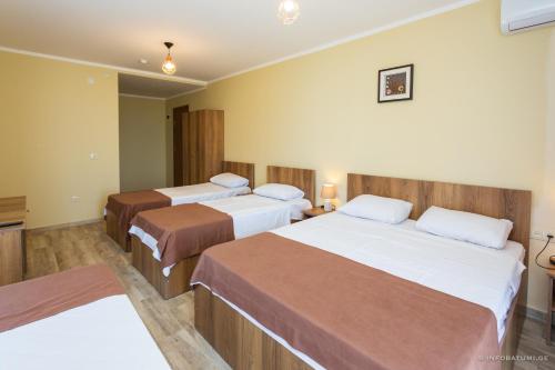 a hotel room with three beds in a room at Hotel Scorpio gonio in Gonio