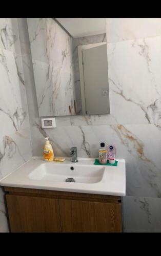 a bathroom with a white sink and a mirror at Studio Hergla in Sidi Bou Ali