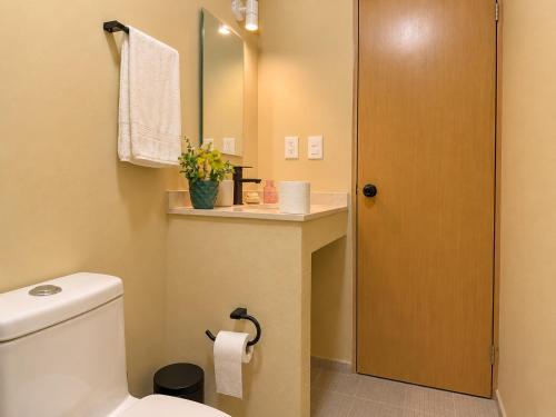 a bathroom with a toilet and a sink and a mirror at Palma 11 Boutique House Downtown Cancun in Cancún