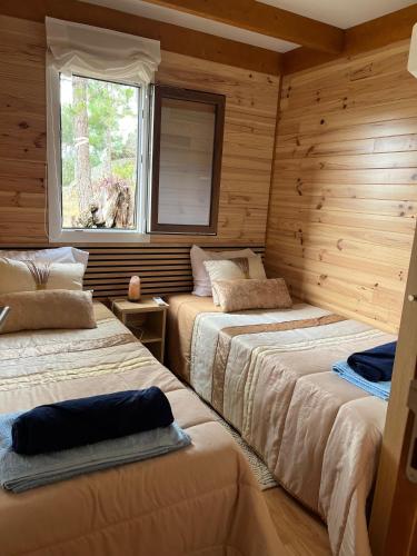 two beds in a room with a window at Pedra Douro in Fontelas