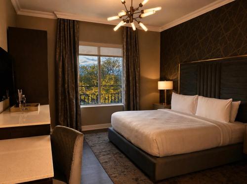 a bedroom with a bed and a desk and a window at The Chateau Grande Hotel in East Brunswick