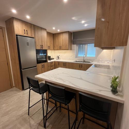 a kitchen with a large white counter and a refrigerator at Golden View Berat, 3BR Apartment with Castle View & Parking in Berat