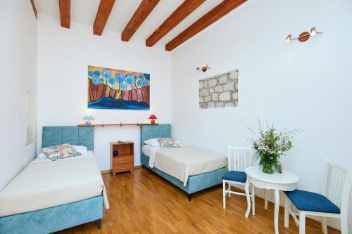 a bedroom with two beds and a table and chairs at Hedera Estate Hedera A34 in Dubrovnik