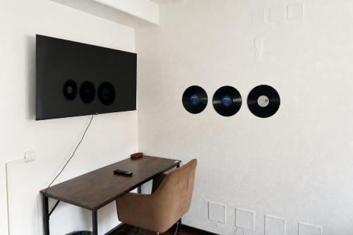 a room with a table with a chair and records on the wall at Music Residence in Saarbrücken