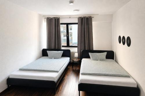 a small room with two beds and a window at Music Residence in Saarbrücken