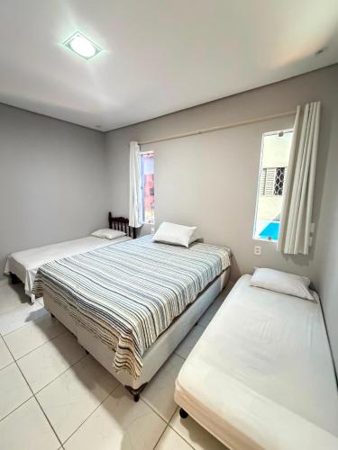 a bedroom with two beds and a window at Paraíso Oculto in Carolina