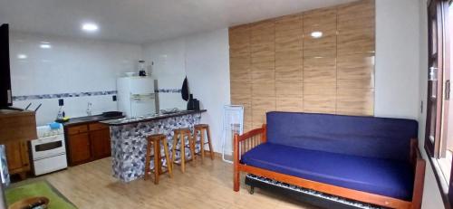 a living room with a blue couch in a kitchen at 001 1 Dormitorio Centro Bombinhas 400 m da praia in Bombinhas