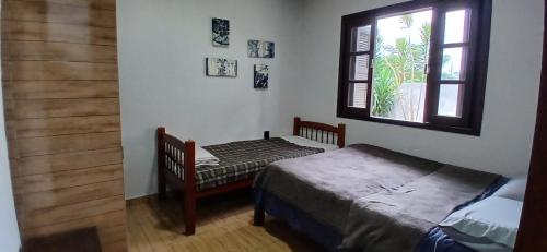 a bedroom with a bed and a window at 001 1 Dormitorio Centro Bombinhas 400 m da praia in Bombinhas