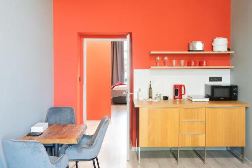 a dining room with orange walls and a table and chairs at Revelton Ostrava in Ostrava