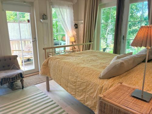 a bedroom with a bed and a chair and windows at Villa Tilda in Matildedal