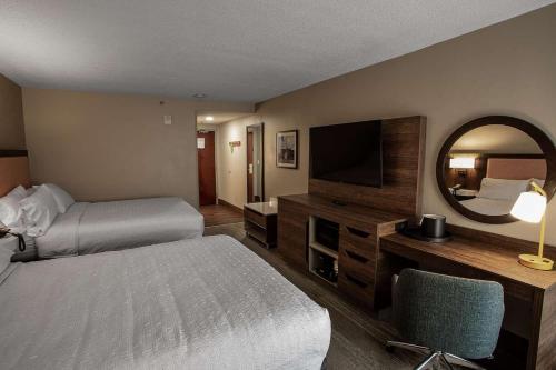 a hotel room with two beds and a television at Hampton Inn Troy in Troy