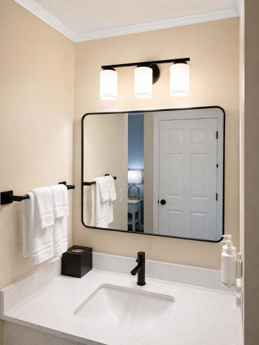 ein Badezimmer mit Waschbecken und großem Spiegel in der Unterkunft Cod Cove Inn, BW Signature Collection-Boothbay Harbor Area in Edgecomb