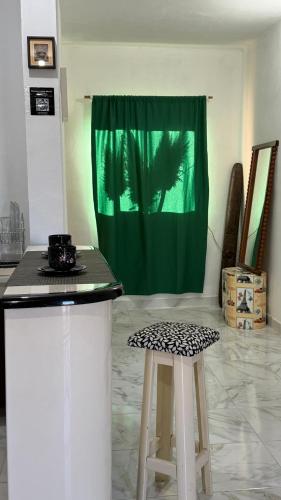 Eine Theke mit zwei Hockern in einem Raum mit einem grünen Vorhang in der Unterkunft ApartWestern in Chilecito
