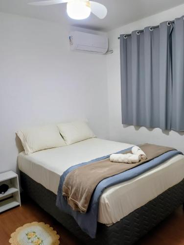 a bedroom with a bed with a blue curtain at Apartamento 5 minutos do parque de exposições in Maringá