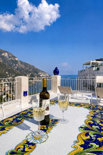 a table with two glasses and a bottle of wine at Love in Blue - La Terrazza di Positano in Positano