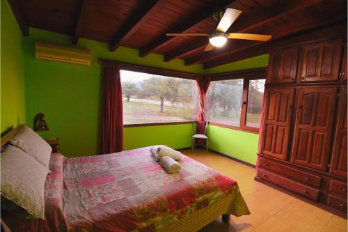 a bedroom with a bed with a teddy bear on it at Complejo cabañas Portal Uritorco in Charbonier