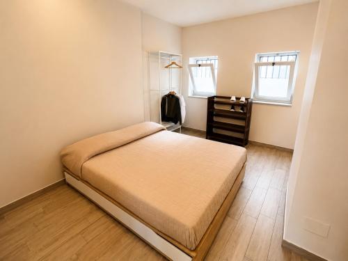 a bedroom with a bed and a dresser and two windows at Lo Studio della Riviera in Naples