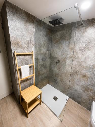a shower with a wooden chair in a bathroom at Lo Studio della Riviera in Naples