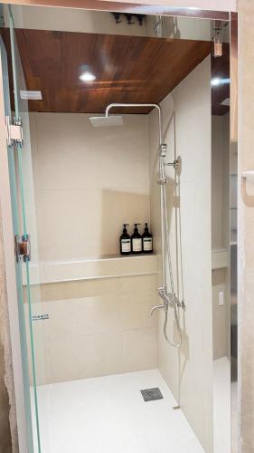 a bathroom with a shower with three bottles on a shelf at Maison de Clare 메종드클레어 in Gyeongju