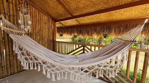 a hammock hanging on a porch of a building at Solenta trace 01 in El Nido