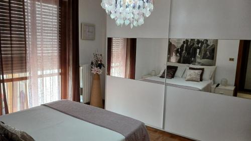 a bedroom with a mirror and a bed and a chandelier at "Da Zia House Comfort e Relax vicino a Torino" in Brandizzo