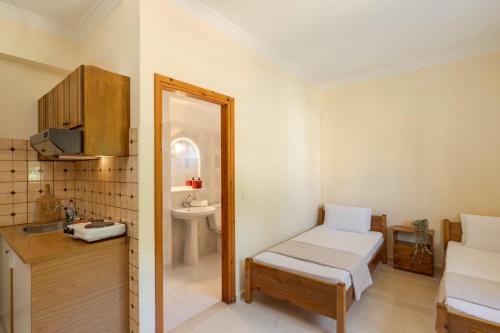 a bedroom with a bed and a sink and a mirror at Kallithea Studios & Apartments in Lakíthra