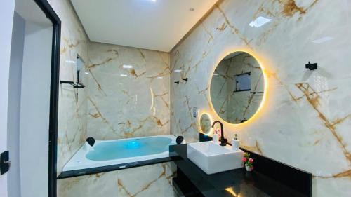 a bathroom with a tub and a sink and a mirror at Casa estadia Capitólio in Capitólio