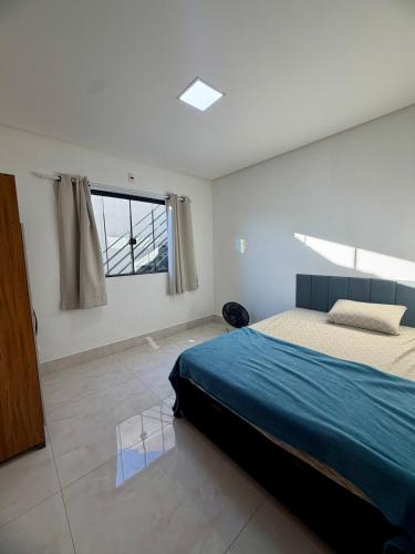 a bedroom with a large bed and a window at Casa estadia Capitólio in Capitólio