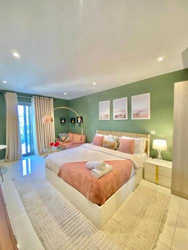 a bedroom with a large bed and a green wall at The Snug Stay - Lennox in Accra