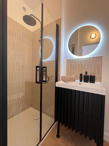 a bathroom with a sink and a shower with a mirror at Maisons Sauvage 3 3 Bis in Romorantin